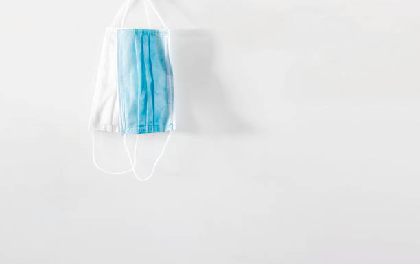 istock a pair of hanging surgical masks isolated on a white background 1264088059