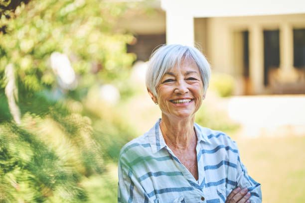 istock Smiling senior woman standing in her backyard in the summer 1264089498