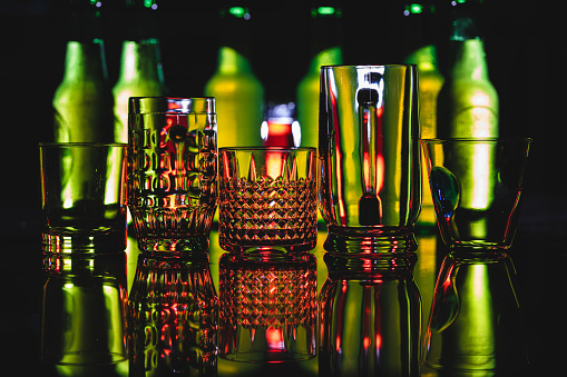 Horizontal view of some empty glasses with some background red and green light effects.