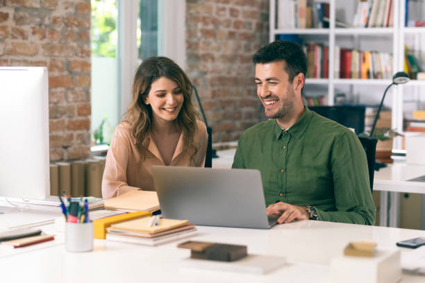 istock Happy Business People Using a Laptop Computer Together at the Office 1264090869