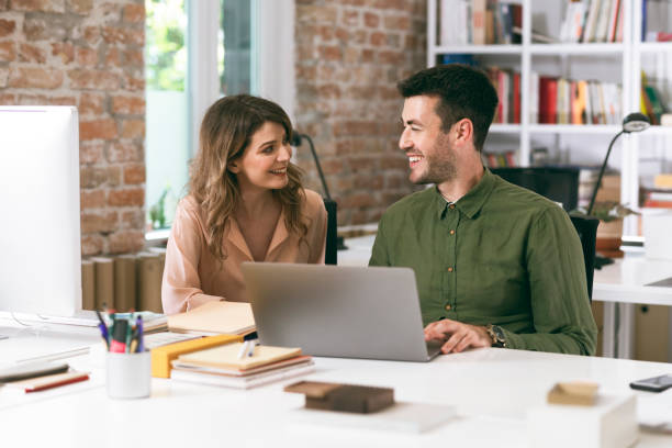 istock Happy Business People Using a Laptop Computer Together at the Office 1264090870