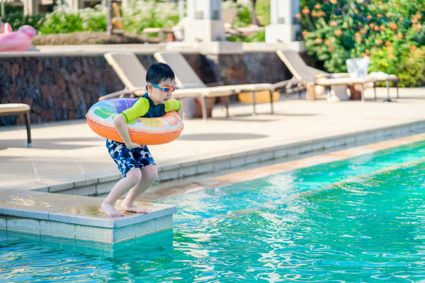 istock Little boy ready to jump into the swimming pool 1264095703
