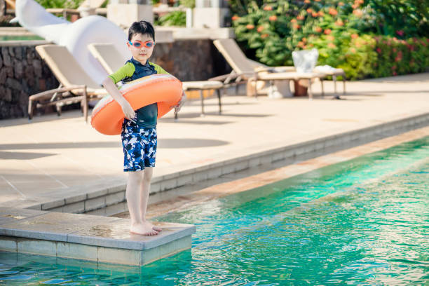 istock Little boy ready to jump into the swimming pool 1264095709