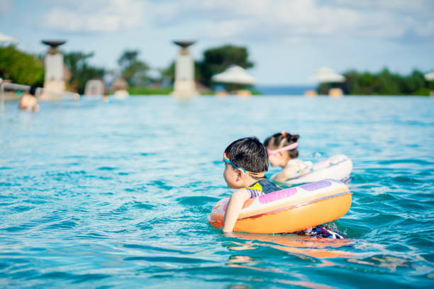 Little asian children enjoying swimming in holiday. Sunny summer day. Slightly soft.