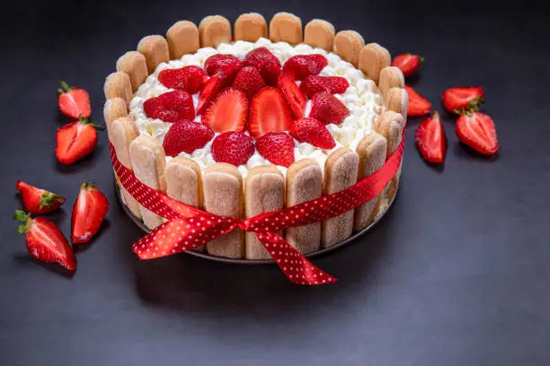 Photo of Homemade strawberry tiramisu cake on black background