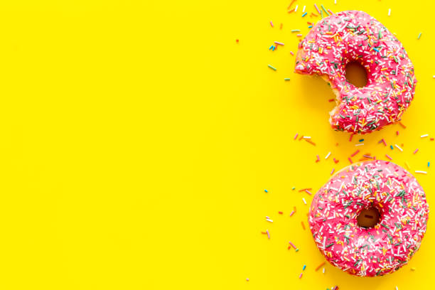 istock Pink berry donuts flat lay, top view. Glazed and sprinkles doughnuts 1264098350