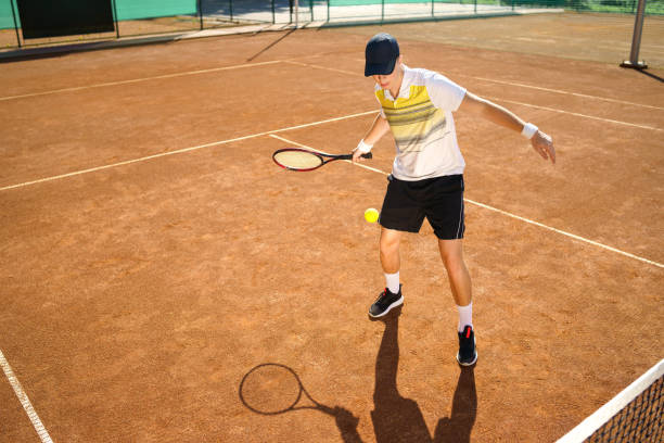 istock Young tennis player hitting the ball 1264101669