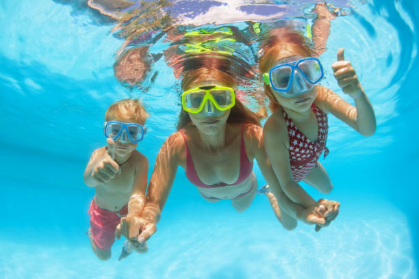 istock Happy family dive underwater with fun in swimming pool 1264102715