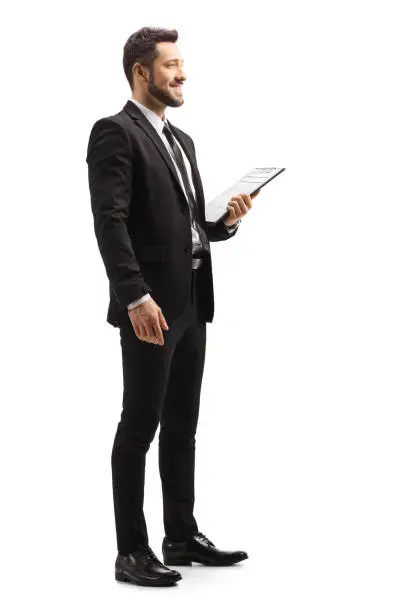 Photo of Elegant man in a black suit holding a clipboard