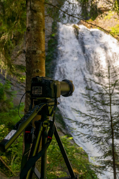 istock photographer equipment near waterfall deep into mountains 1264108779
