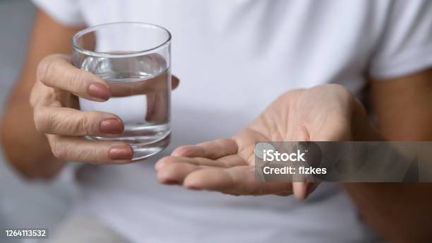 Closeup Mature Woman Hands Holding Pill And Glass Of Water Stock Photo - Download Image Now