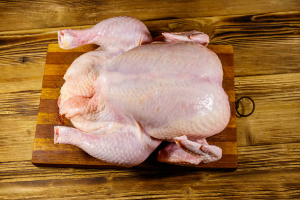 istock Raw whole chicken on a wooden table. Top view 1264113756