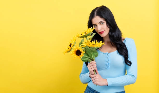 istock Young woman with sunflowers 1264116416