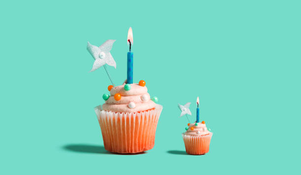 istock Big and small cupcakes with lit candles 1264116457