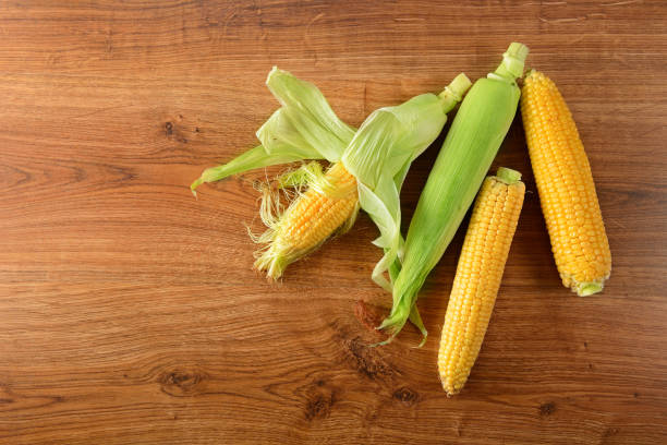 istock Fresh corn on cobs on wooden table, closeup, top view. 1264116681