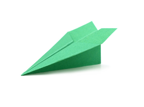 A green paper plane on white