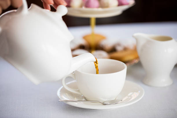 白い陶器のティーカップに熱い英語のお茶を注ぐ - tea afternoon tea tea party cup ストックフォトと画像