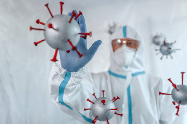 istock Man in protective suit stopping covid-19 molecules 1264121567