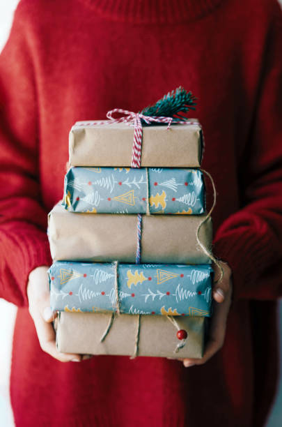 istock woman holding a stack of gifts 1264122000