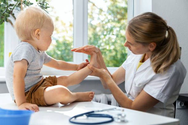 ortopedico femminile esaminando le condizioni del piede del bambino piccolo in clinica - podiatrist foto e immagini stock