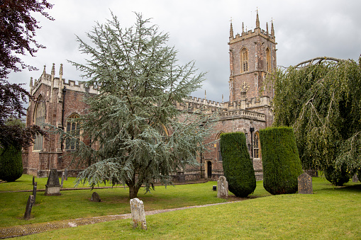 St Peter's Church and graveyard Tiverton in Devon. Trees and grass with grave stones - Church of England