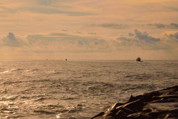 barche da pesca in viaggio verso l'atlantico all'alba - maryland fishing atlantic ocean sea foto e immagini stock