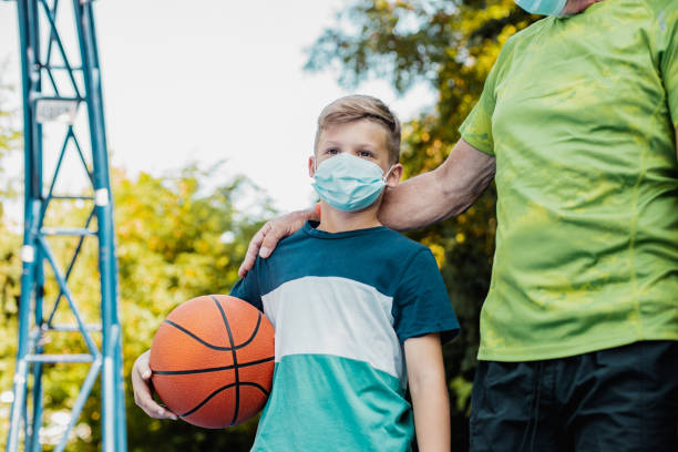 istock Boy and his grandfather playing basket during epidemic 1264127378