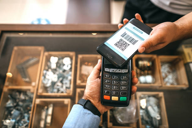 Contactless payment using credit card reader and mobile phone app Shop owner receiving contactless payment using mobile phone app and credit card reader at checkout bar code photos stock pictures, royalty-free photos & images