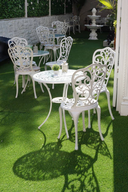 istock openwork white metal tables and chairs on a green lawn 1264130454