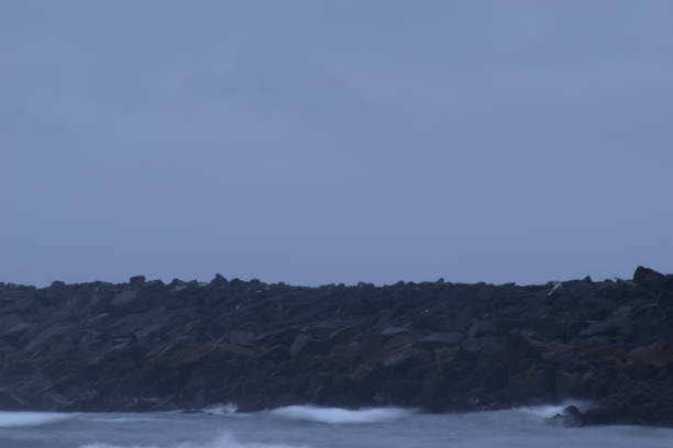 istock Jetty Heading Out To Sea With Rough Waves During A Cloudy Sunrise 1264131338