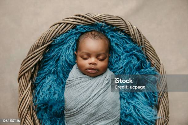 Sweet Sleeping Africanamerican Newborn Baby Boy Swaddled In A Blanket And Lying In A Basket Stock Photo - Download Image Now
