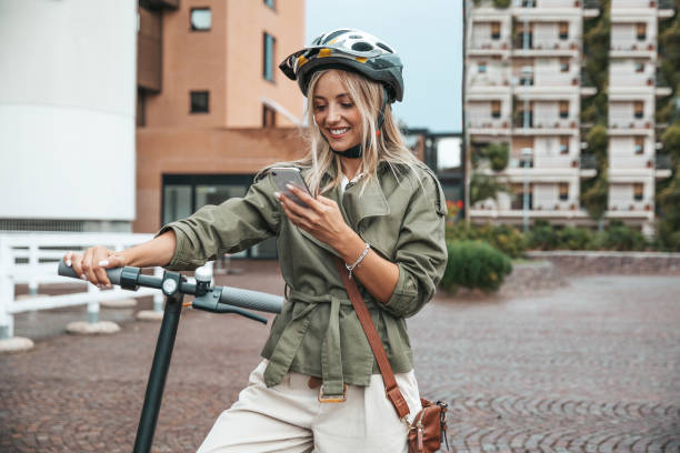 istock Woman stopping to send a text while commuting to work using a electric scooter 1264139674