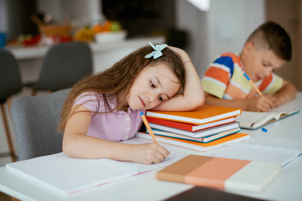 istock Elementary school kids doing homework at home stock photo 1264140524