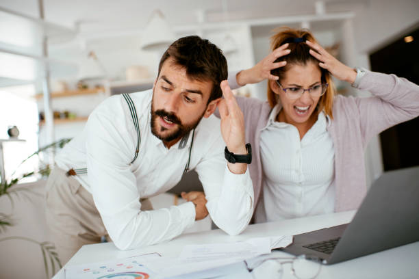 istock Frustrated couple checking bills at home using laptop stock photo 1264141159