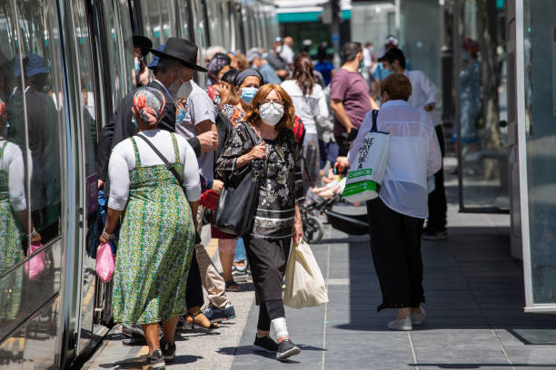 Coronavirus Outbreak. People wearing face masks walk at Jaffa Street train station. hasidism photos stock pictures, royalty-free photos & images