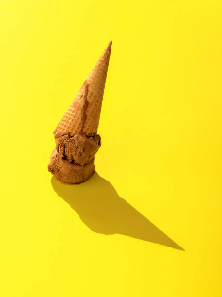 istock Chocolate ice cream dropped. Cone ice cream upside down on a yellow background. 1264142210