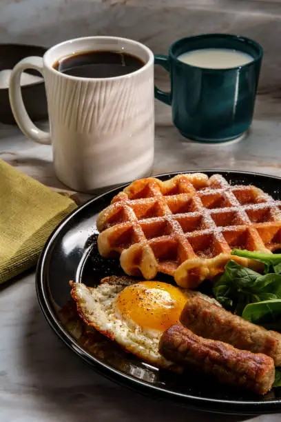Belgian waffle breakfast served with sausage eggs and coffee