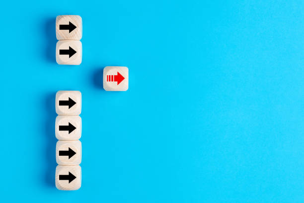 istock Wooden blocks with arrows with one moving forward and standing out from the crowd 1264144309