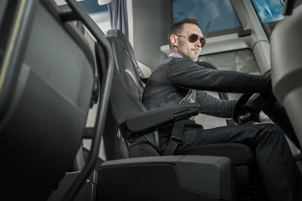 caucasian male coach bus driver behind vehicle wheel - bus coach bus travel tour bus imagens e fotografias de stock