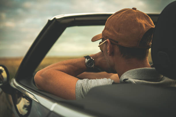 istock Men Behind Convertible Car Steering Wheel 1264145776