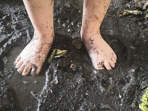 a child barefeet in the puddle