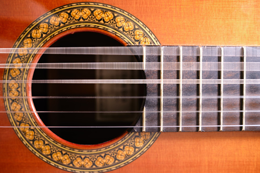 Primer plano de la guitarra acústica con cuerdas vibratorias photo