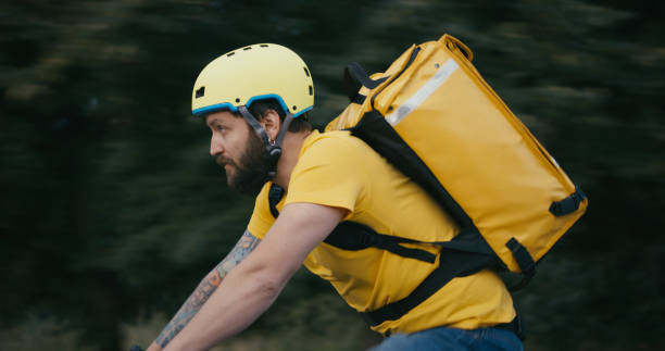 bicycle messenger cycling on a road - bicycle messenger imagens e fotografias de stock