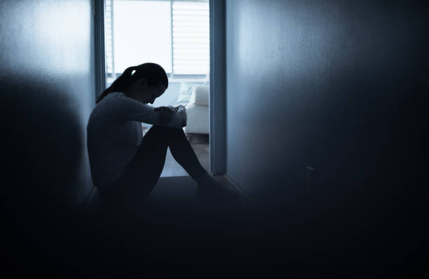 istock Young woman sitting alone on floor at home feeling sad looking down. 1264155461