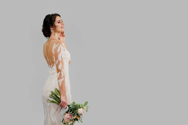 istock Bride in luxury wedding dress with bouquet in studio on white blank background right side. Advert for social networks for wedding agency and bridal salon 1264156650