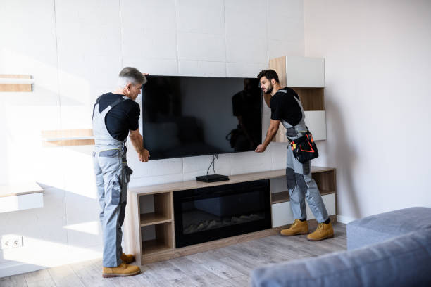 Full length shot of two professional technicians, workers in uniform installing television on the wall indoors. Construction, maintenance and delivery concept Full length shot of two professional technicians, workers in uniform installing television on the wall indoors. Construction, maintenance and delivery concept. Selective focus. Horizontal shot installing tv stock pictures, royalty-free photos & images