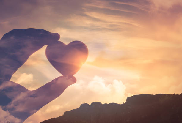 istock Hand holding heart on sunset sky. 1264157034