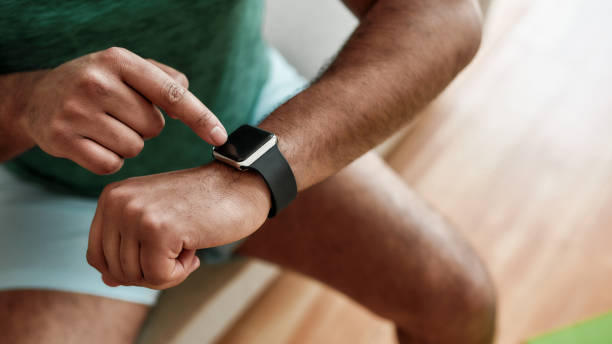 istock Technology. Close up of hands of active man checking time, using smartwatch while doing morning workout at home. Fitness, motivation concept 1264157810