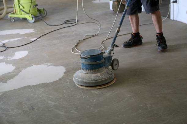 Worker grinding the floor using a single disc machine stock photo