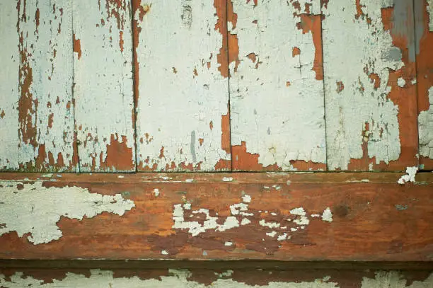 Texture of old wooden boards with peeling paint. A fence or a wall of a house.